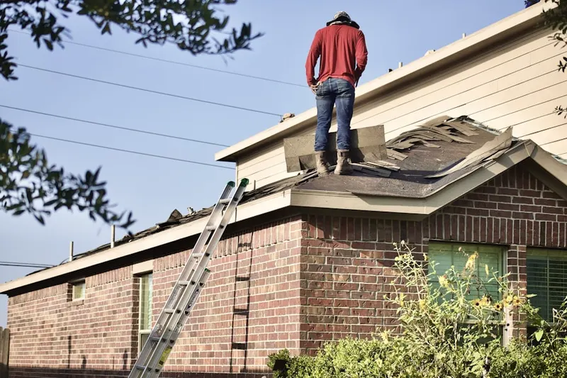 Professional roofer working on a residential roof in Country Club Plaza